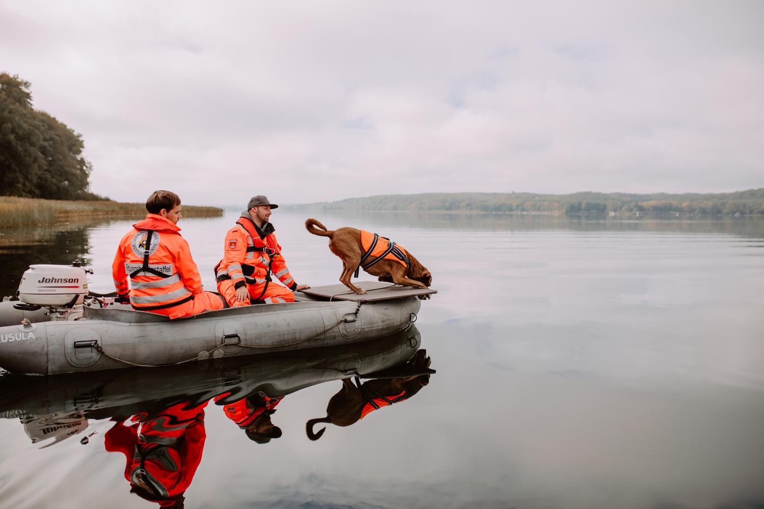 zwei BRH-Rettungshundestaffel Mitglieder mit Hund zusammen auf einem Boot auf einem See